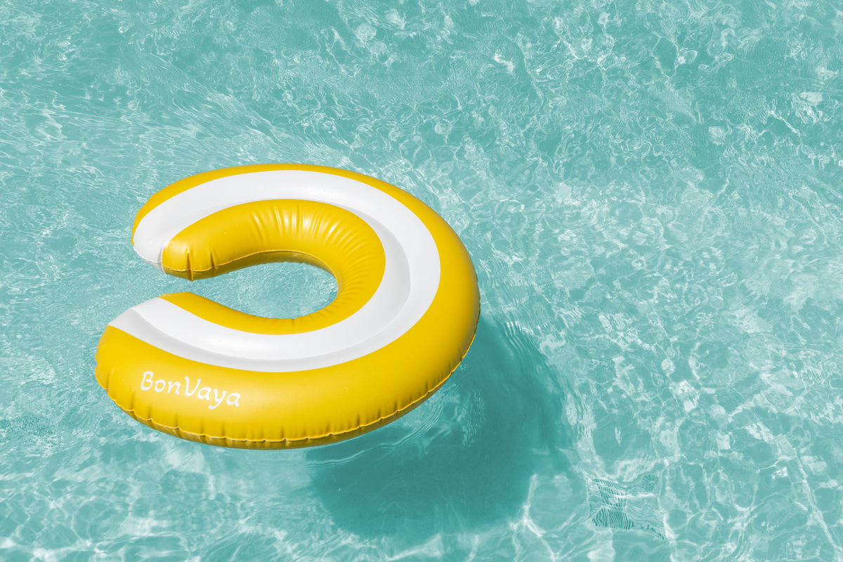 Woman floating in pool with BonVaya float and drink